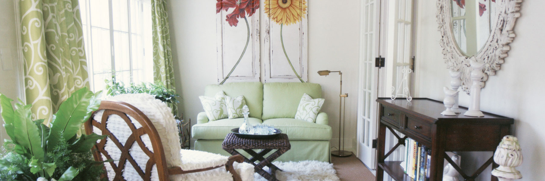 Green and white drapes, green sofa, white rug, floral art